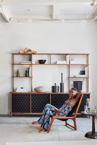 Woman lounging in wood chair with bespoke livingroom console