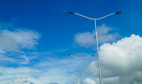 Low angle view of wind turbines against blue sky