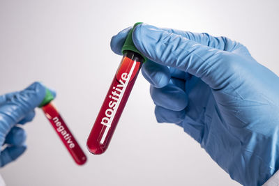 Close-up of hand holding paper over white background
