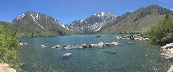 Scenic view of lake and mountains against blue sky