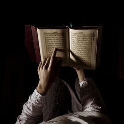 Midsection of woman reading koran