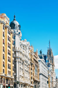 Low angle view of buildings against clear blue sky