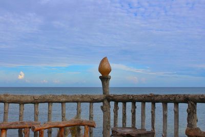 Wooden posts on beach against sky
