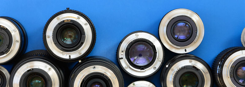 Directly above shot of various lenses on blue background