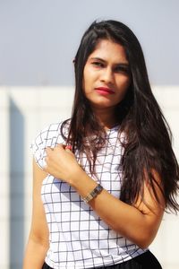 Portrait of beautiful woman standing against wall