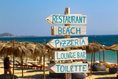 Information sign on beach against clear sky