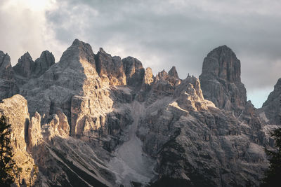 Panoramic view of rocky mountains against cloudy sky