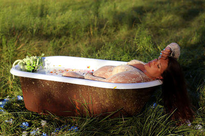 Low section of woman sitting on grass