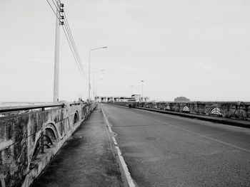 Road by bridge against sky