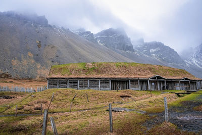 Wooden traditional house in viking village under vestrahorn mountain against sky
