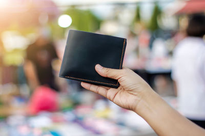 Close-up of woman holding wallet outdoors