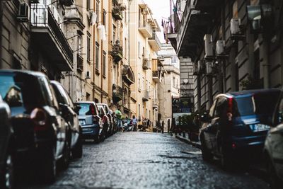 Vehicles on road amidst buildings in city