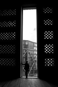 Rear view of silhouette man walking in building