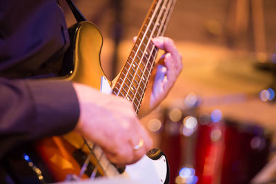 Midsection of man playing guitar