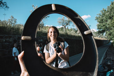 Portrait of woman photographing through camera