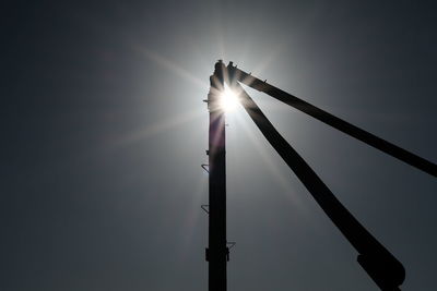 Low angle view of sun shining through clouds