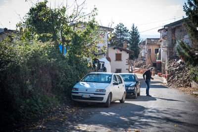 Cars on street by buildings against sky