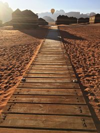 Boardwalk on sand against sky