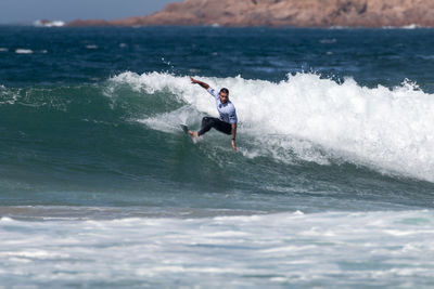 Full length of man surfing in sea against sky