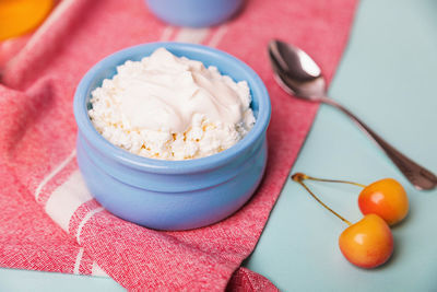 Cottage cheese in a blue bowl with sour cream and honey.