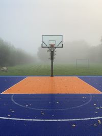 View of basketball hoop on field against sky