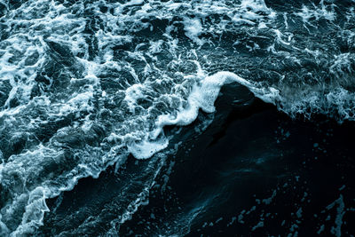 High angle view of waves splashing on rocks