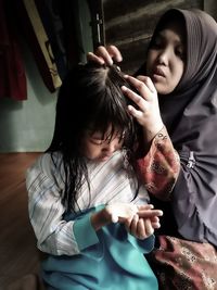 Woman cleaning daughter hair