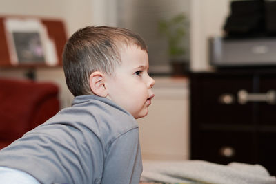 Expressive young boy watching cartoons in the livingroom