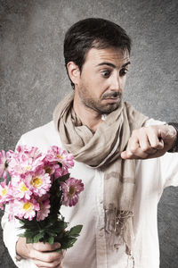 Portrait of young man holding flower bouquet
