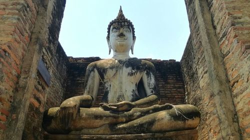 Low angle view of buddha statue against clear sky