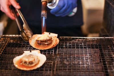 Midsection of chef preparing food on barbecue