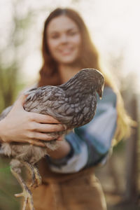 Portrait of young woman holding bird