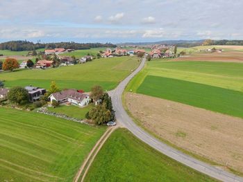 High angle view of field and buildings against sky