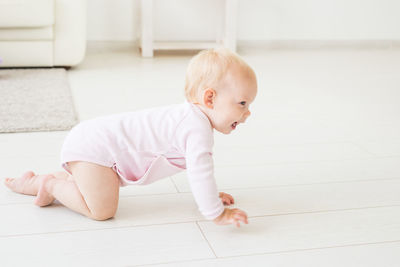 Cute baby girl crawling at home