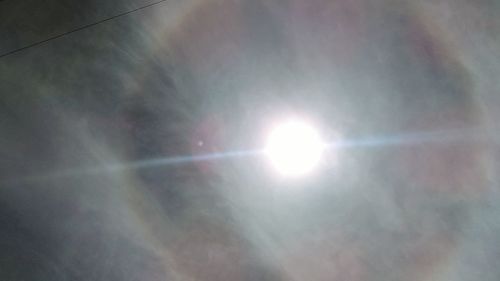 Low angle view of sun shining in sky