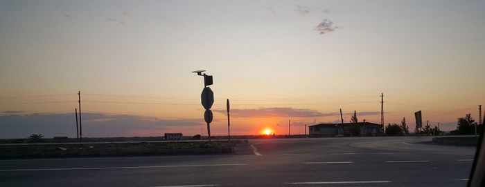 Street lights against sky during sunset