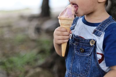 Midsection of boy eating ice cream