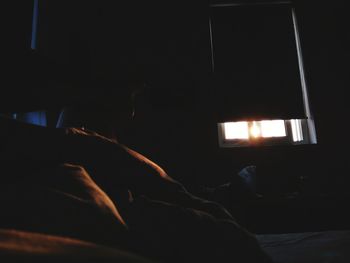 Close-up of man relaxing on bed at home