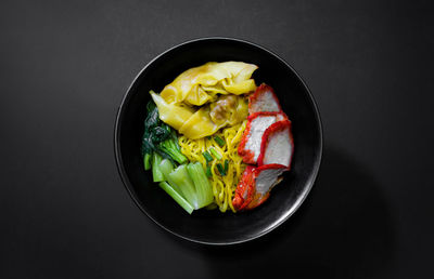 High angle view of fruits in bowl against black background