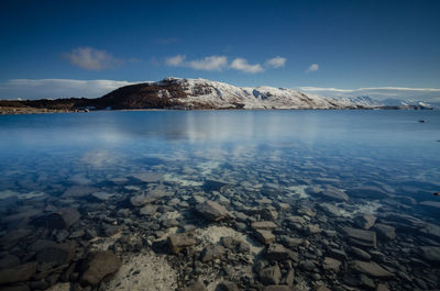 Scenic view of lake against sky during winter