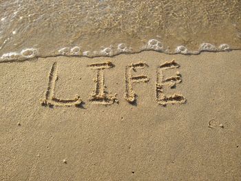 High angle view of text on sand at beach