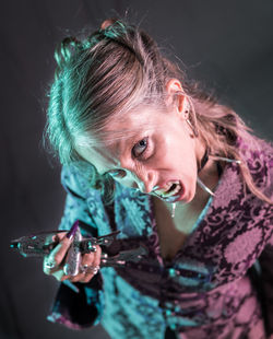 Portrait of spooky woman standing against black background