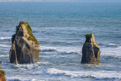 Rock formation in sea against sky