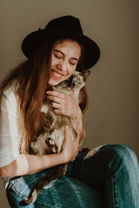 Portrait of smiling young woman holding hat