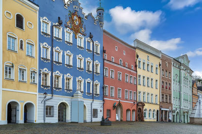 Residential buildings by street against sky