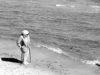 Full length of woman standing on shore at beach during sunny day