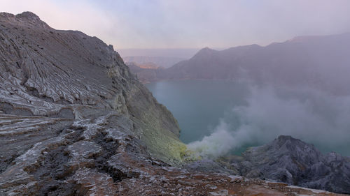 Smoke emitting from volcanic mountain against sky