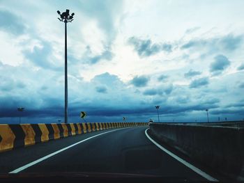 Diminishing perspective of road against sky seen through car windshield