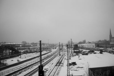 High angle view of snow covered railroad tracks against clear sky