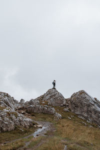 Low angle view of man on rock against sky